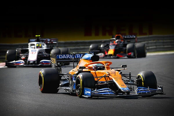 Action Pirelli. Daniel Ricciardo, McLaren MCL35M, leads Mick Schumacher, Haas VF-21,